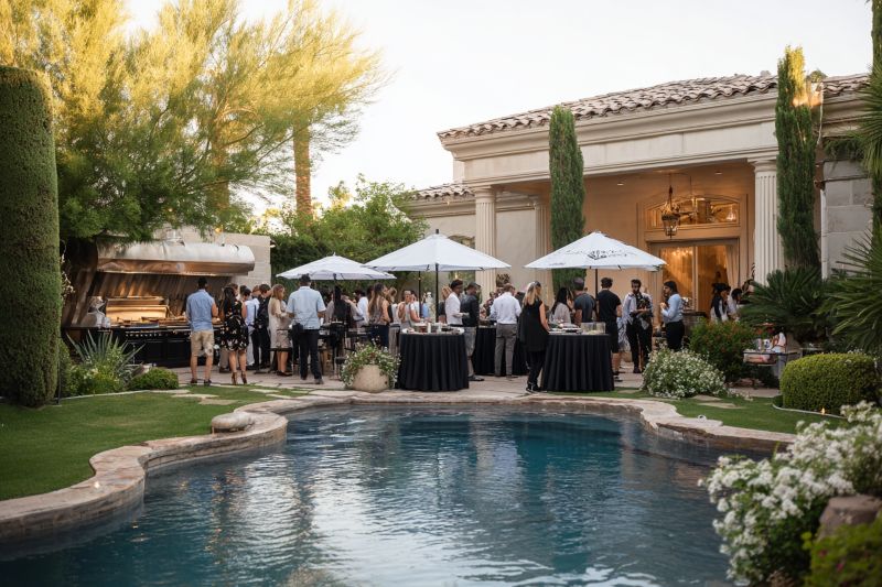 Guests gathered around outdoor catering stations beside a pool at a Scottsdale home